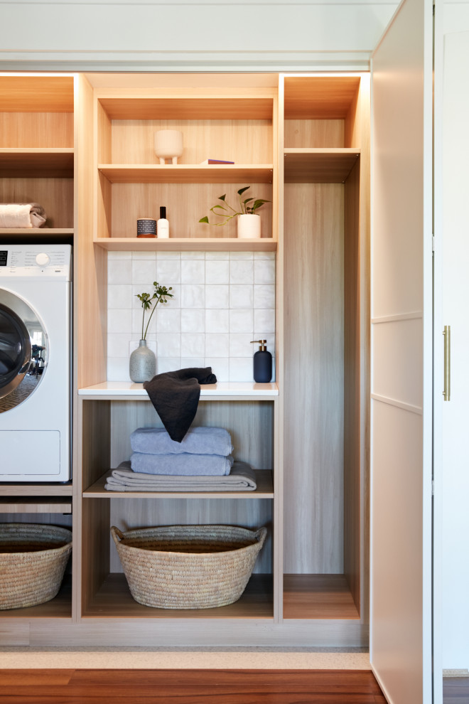 This is an example of a small contemporary single-wall dedicated laundry room in Sydney with shaker cabinets, white cabinets, white splashback, ceramic splashback, ceramic floors, a side-by-side washer and dryer and white floor.
