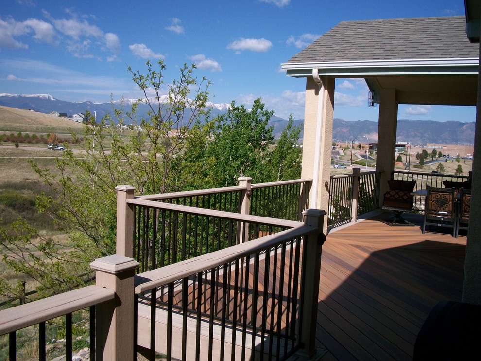Example of a mid-sized trendy backyard second story metal railing deck design with a roof extension