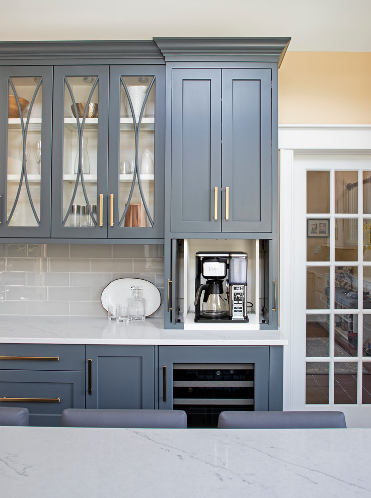 Kitchen - large transitional u-shaped medium tone wood floor kitchen idea with an undermount sink, gray cabinets, quartz countertops, gray backsplash, glass tile backsplash, paneled appliances, an island and white countertops