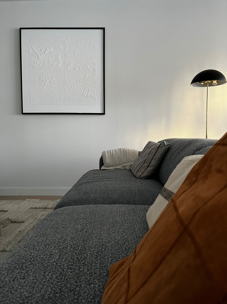 Exemple d'un grand salon tendance ouvert avec un mur blanc, parquet clair, un téléviseur fixé au mur et un sol beige.