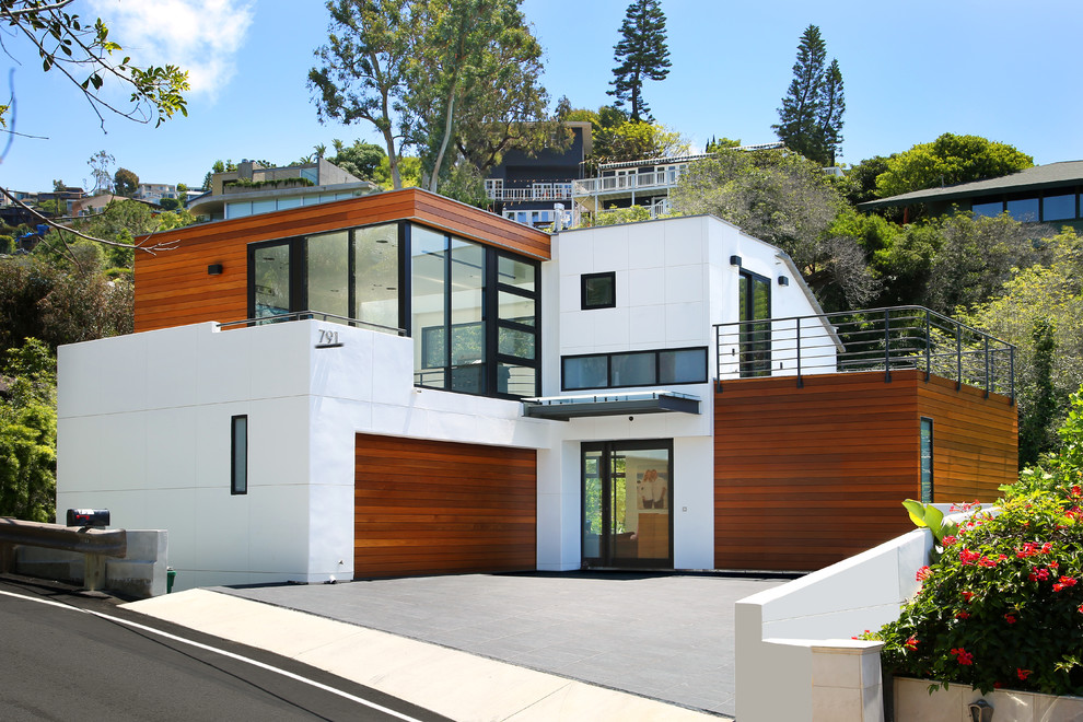 This is an example of a large modern three-storey white house exterior in Orange County with mixed siding and a flat roof.