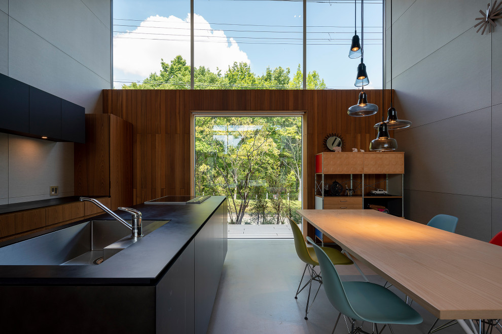 Large modern kitchen/dining combo in Kobe with grey walls, concrete floors and grey floor.