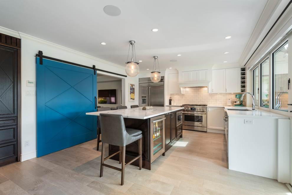 Transitional beige floor kitchen photo in Vancouver with white backsplash, stainless steel appliances, an island and white countertops