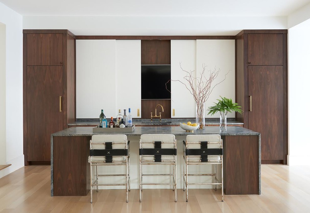 Large contemporary single-wall seated home bar in DC Metro with an undermount sink, flat-panel cabinets, dark wood cabinets, light hardwood floors, beige floor, grey benchtop and granite benchtops.