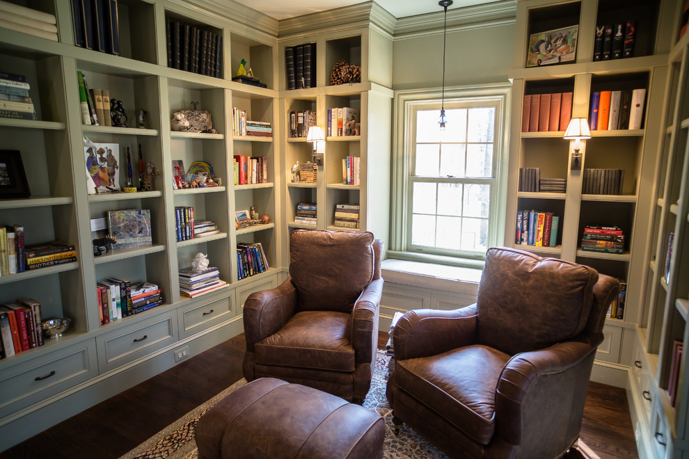 This is an example of a mid-sized traditional home office in DC Metro with a library, green walls, dark hardwood floors, brown floor and no fireplace.