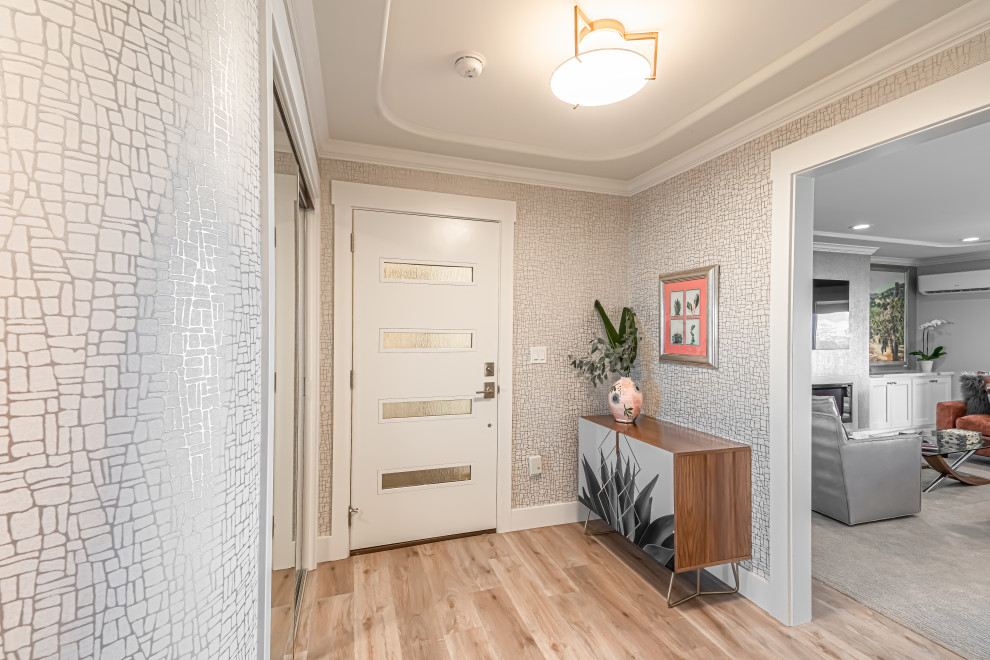 This is an example of a small transitional foyer in San Francisco with metallic walls, vinyl floors, a single front door, a white front door, grey floor, recessed and wallpaper.