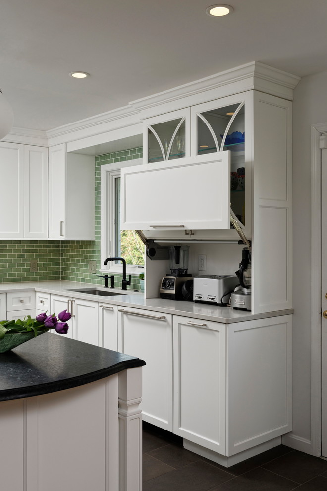 Photo of a mid-sized transitional kitchen in DC Metro with a single-bowl sink, white cabinets, quartz benchtops, green splashback, ceramic splashback, stainless steel appliances, porcelain floors, with island, brown floor, white benchtop and recessed-panel cabinets.