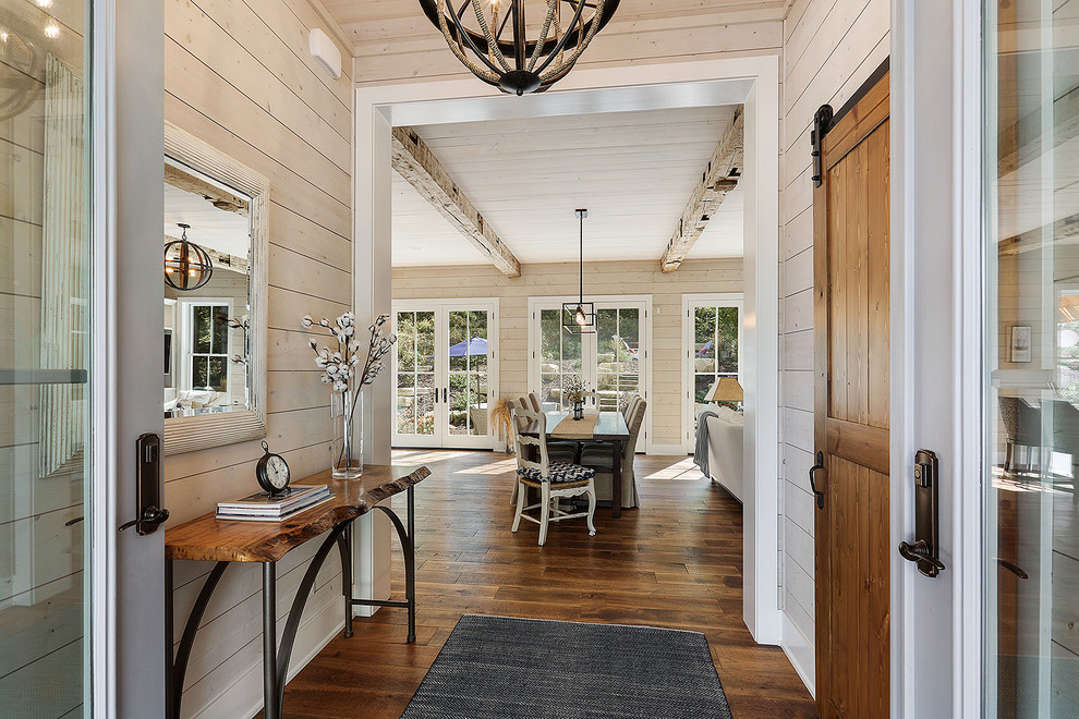 This is an example of a mid-sized beach style front door in Other with brown walls, dark hardwood floors, a single front door, a dark wood front door and brown floor.