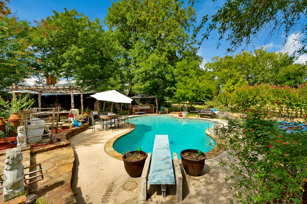 Expansive eclectic backyard custom-shaped pool in Dallas with a water feature.