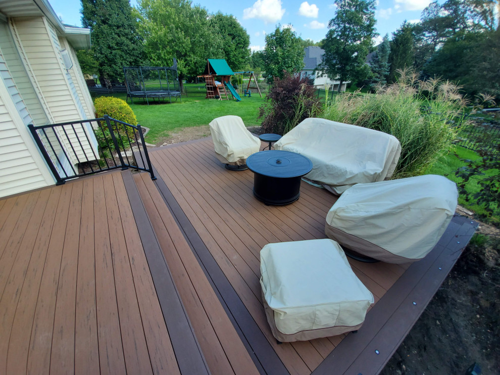 Inspiration for a large backyard ground level metal railing deck remodel with a roof extension