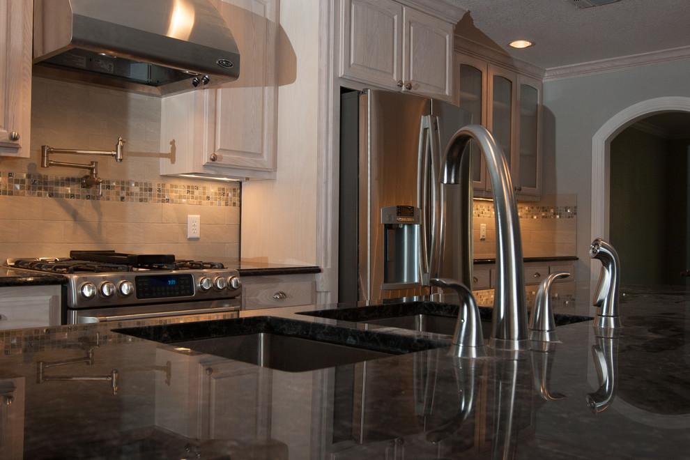 Inspiration for a large modern single-wall dark wood floor eat-in kitchen remodel in Dallas with a double-bowl sink, raised-panel cabinets, light wood cabinets, granite countertops, beige backsplash, ceramic backsplash, stainless steel appliances and an island