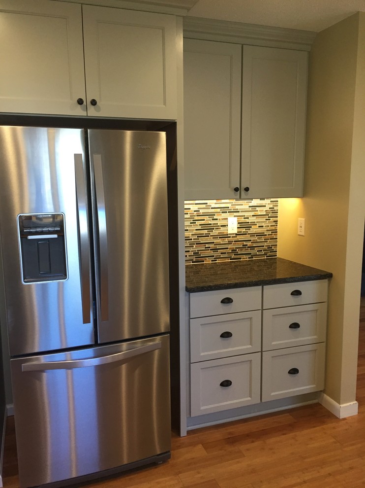 Mid-sized transitional u-shaped kitchen pantry photo with recessed-panel cabinets, gray cabinets, quartzite countertops, multicolored backsplash, stainless steel appliances and a peninsula