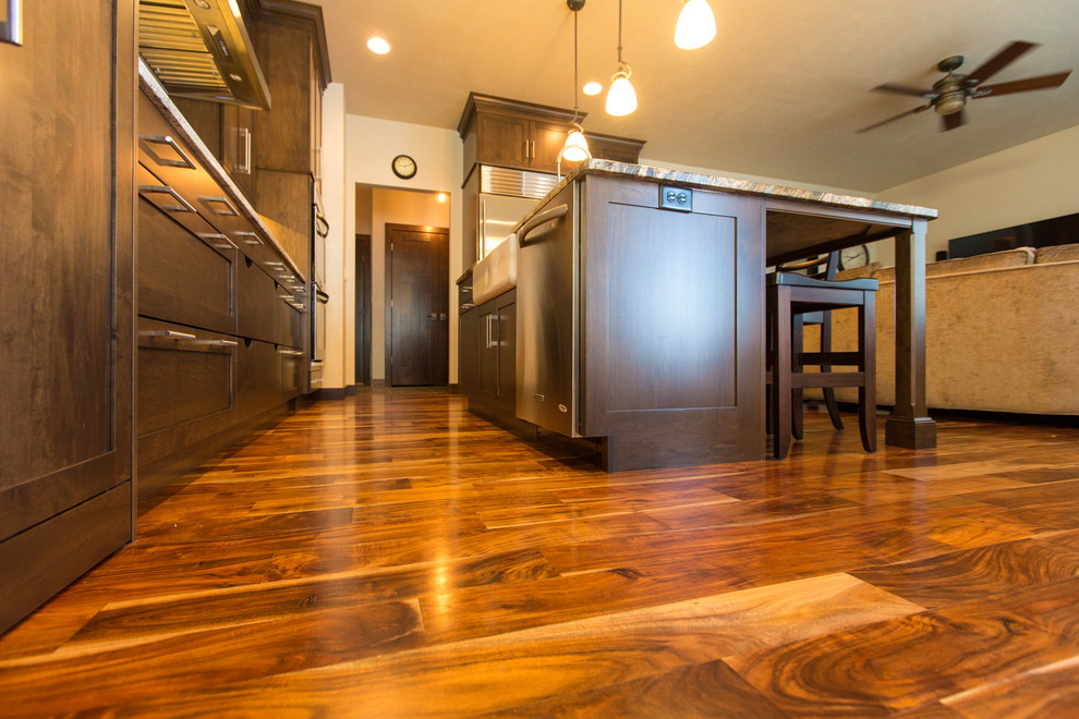 Example of a large transitional l-shaped dark wood floor and brown floor open concept kitchen design with a farmhouse sink, shaker cabinets, dark wood cabinets, granite countertops, beige backsplash, subway tile backsplash, stainless steel appliances and an island