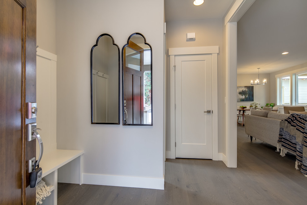 Example of a small transitional light wood floor and beige floor foyer design with beige walls and a dark wood front door