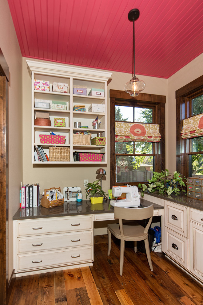 This is an example of a mid-sized traditional craft room in Other with brown walls, dark hardwood floors, no fireplace and a built-in desk.