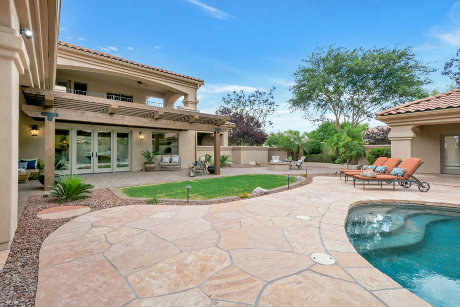 Inspiration for a large transitional backyard concrete paver patio remodel in Phoenix with a fire pit and a pergola