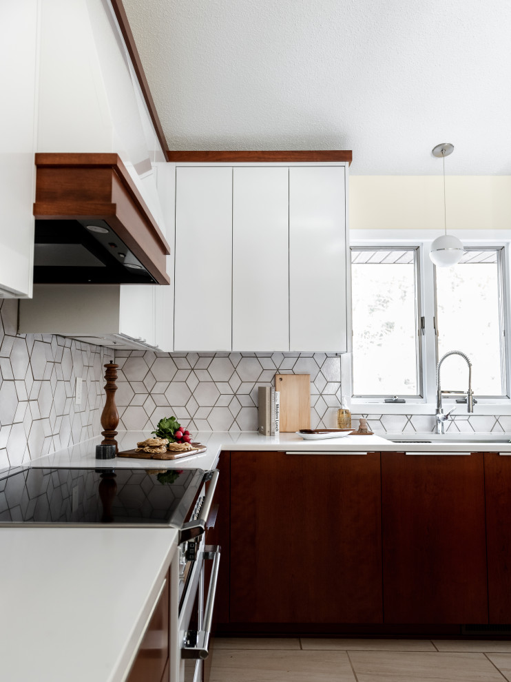 На фото: угловая кухня в стиле ретро с обеденным столом, белыми фасадами, столешницей из кварцевого агломерата, серым фартуком, фартуком из плитки мозаики, белой техникой и белой столешницей с