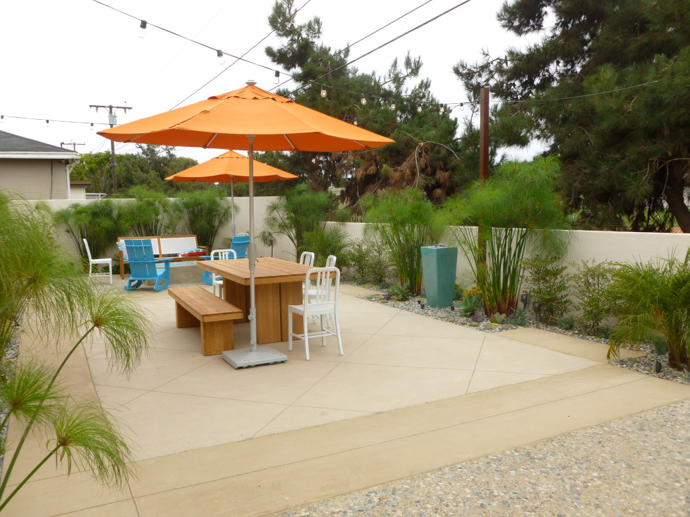 Photo of a small beach style backyard patio in Los Angeles with a fire feature and concrete slab.