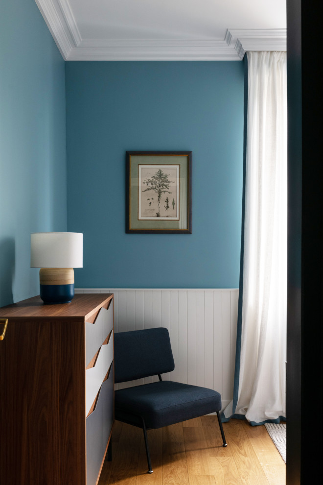 Cette photo montre une grande chambre d'enfant tendance avec un mur bleu, parquet clair, un sol beige et du papier peint.