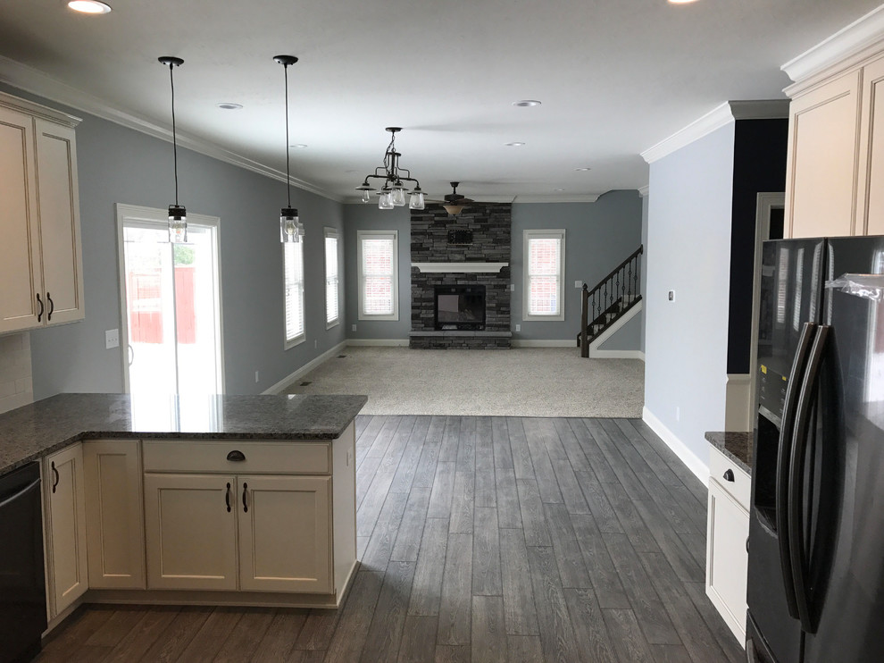 Mid-sized open plan dining in Indianapolis with grey walls, vinyl floors, a standard fireplace, a brick fireplace surround and grey floor.