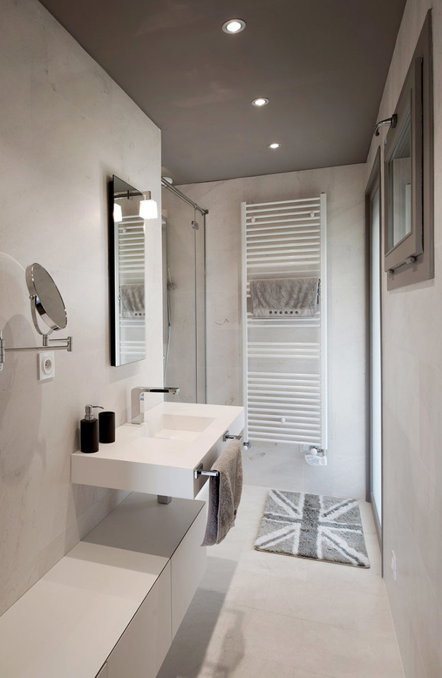 Photo of a mid-sized modern 3/4 bathroom in Lyon with a wall-mount sink, flat-panel cabinets, grey cabinets, an alcove shower and grey walls.