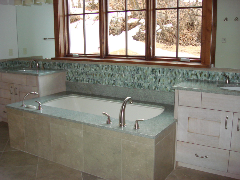 This is an example of a large contemporary bathroom in Denver with flat-panel cabinets, light wood cabinets, granite benchtops, an undermount tub and green tile.
