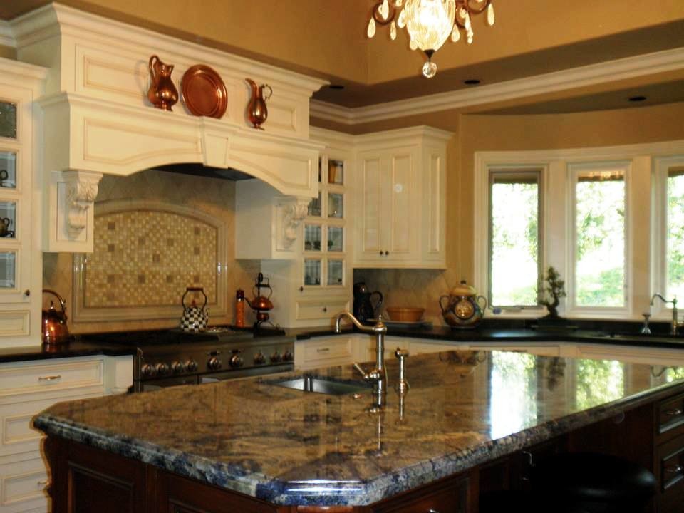 Inredning av ett klassiskt avskilt l-kök, med en nedsänkt diskho, släta luckor, vita skåp, beige stänkskydd, stänkskydd i keramik, rostfria vitvaror, mörkt trägolv och en köksö