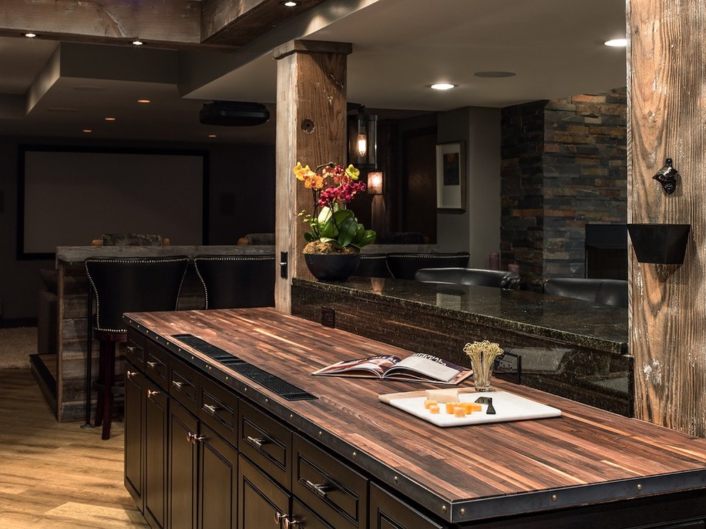 Country single-wall wet bar in Chicago with no sink, raised-panel cabinets, brown cabinets, wood benchtops, multi-coloured splashback, stone slab splashback and porcelain floors.