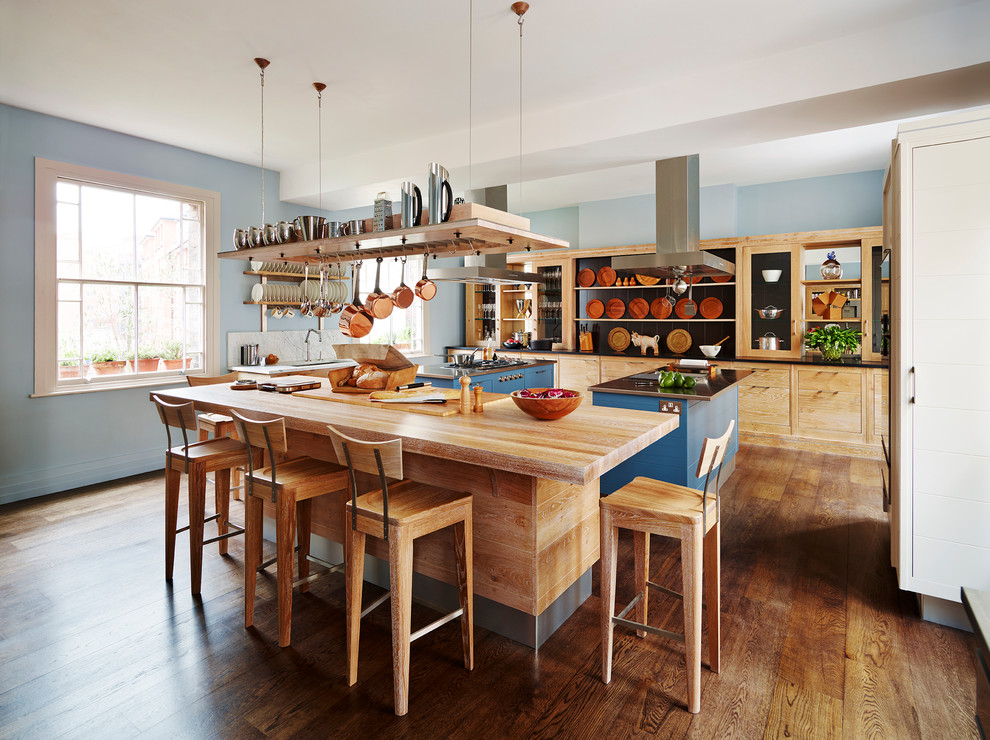 Design ideas for a country kitchen in London with flat-panel cabinets, dark hardwood floors and multiple islands.