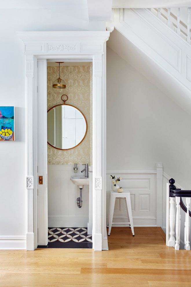 Small transitional powder room in New York with beige walls, a wall-mount sink, multi-coloured floor and cement tiles.