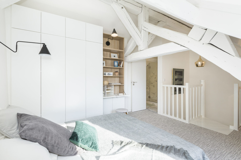 This is an example of a mid-sized scandinavian loft-style bedroom in Paris with white walls, carpet, grey floor and no fireplace.