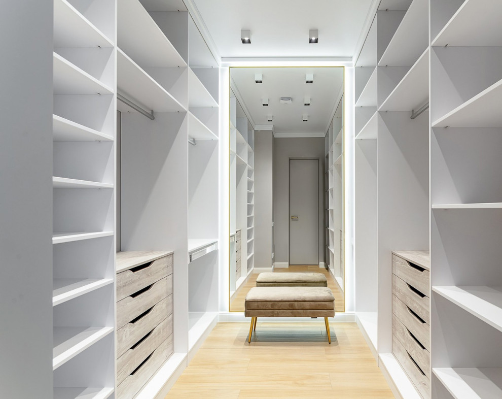 Inspiration for a large contemporary gender-neutral walk-in wardrobe in Other with light wood cabinets, porcelain floors and beige floor.