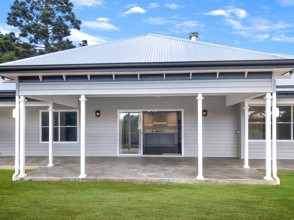 Photo of a large traditional front yard verandah in Brisbane with a roof extension.