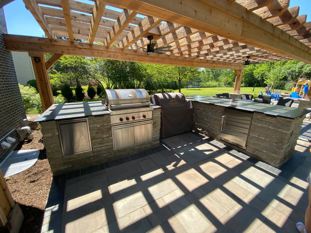 Foto de patio clásico renovado grande en patio trasero con cocina exterior, adoquines de ladrillo y pérgola