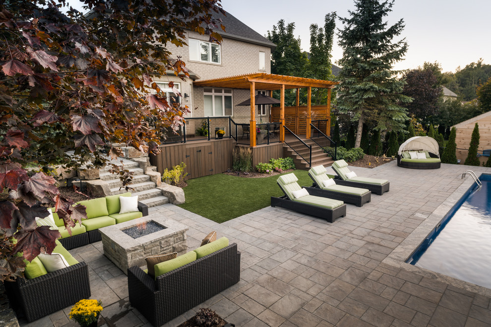 Immagine di un grande patio o portico eclettico dietro casa con un focolare, pavimentazioni in mattoni e una pergola