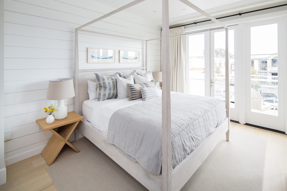 Photo of a beach style bedroom in Orange County with white walls, light hardwood floors and beige floor.