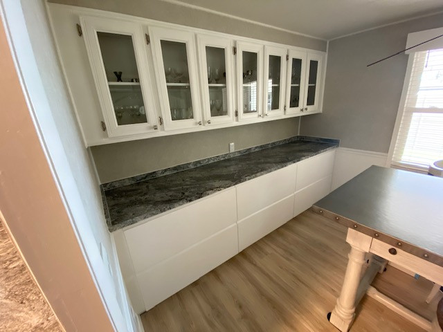 Small galley enclosed kitchen photo with a double-bowl sink, laminate countertops, black appliances, no island and black countertops