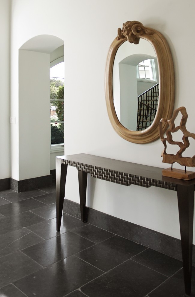 This is an example of a large modern foyer in Phoenix with white walls, limestone floors, a single front door, a black front door and black floor.