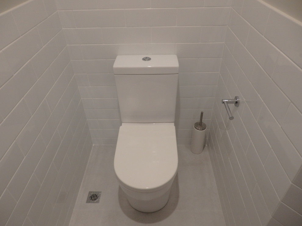 Esempio di un bagno di servizio nordico di medie dimensioni con ante lisce, ante in legno chiaro, piastrelle bianche, pareti bianche, lavabo a bacinella e top in quarzo composito