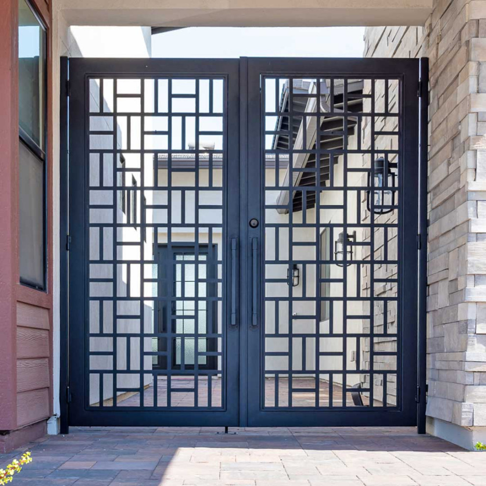 Cette image montre une grande entrée traditionnelle avec une porte double et une porte noire.