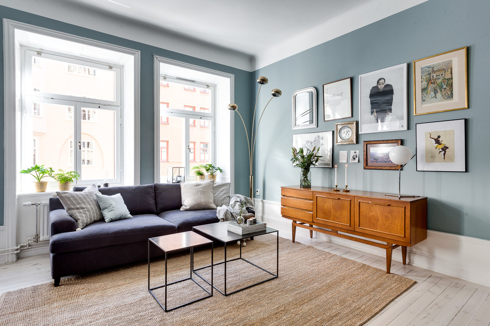 Mid-sized transitional formal living room in Stockholm with blue walls, light hardwood floors, no fireplace and no tv.