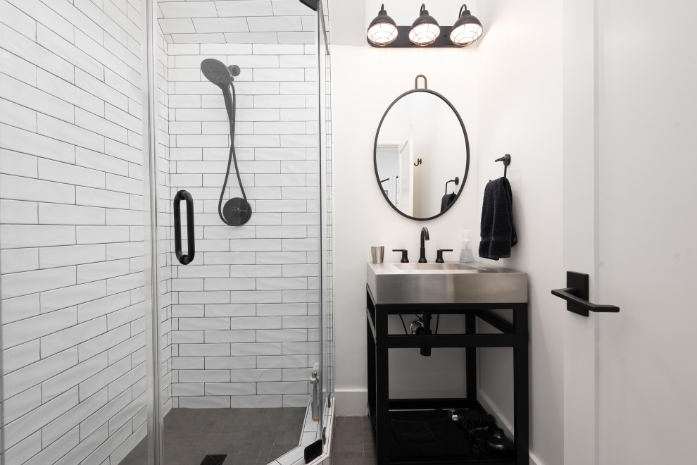 Mid-sized ceramic tile, black floor and single-sink corner shower photo in Other with furniture-like cabinets, dark wood cabinets, white walls, an integrated sink, stainless steel countertops, a hinged shower door and a freestanding vanity