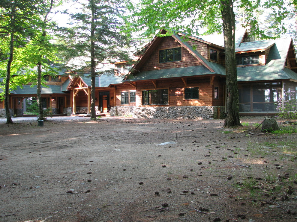Example of a large mountain style brown two-story wood exterior home design with a shed roof