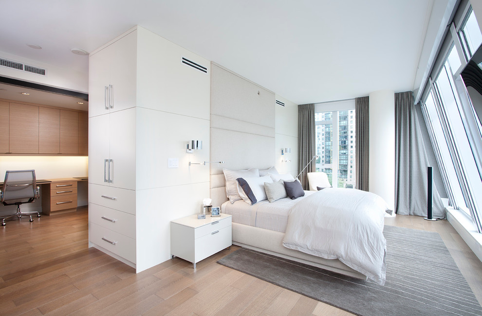 Photo of a contemporary bedroom in Vancouver with white walls and medium hardwood floors.