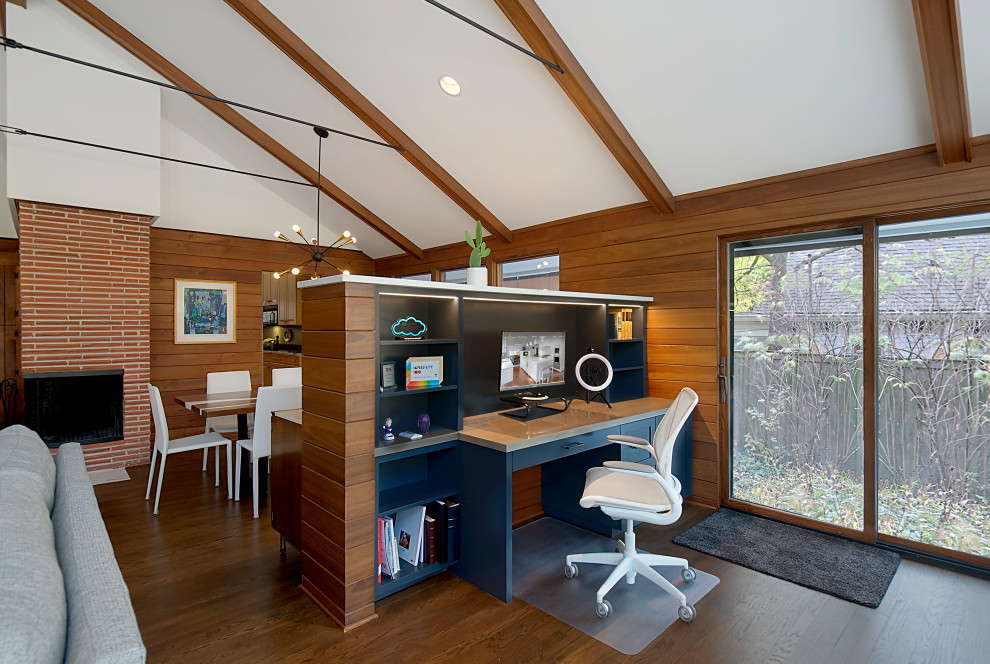 Aménagement d'un petit bureau rétro avec un mur marron, un sol en bois brun, un bureau intégré, un sol marron, un plafond voûté et du lambris.