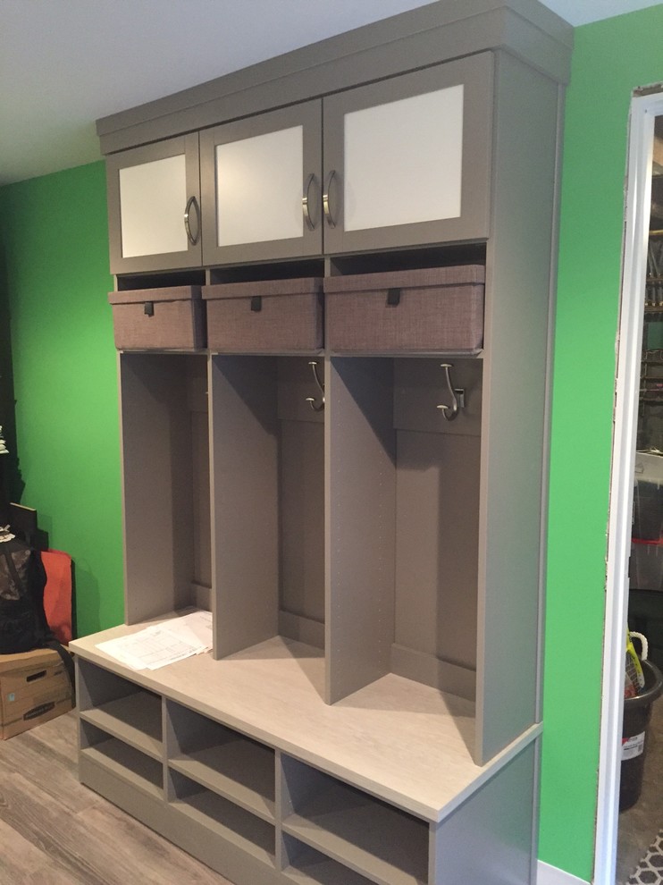 Inspiration for a mid-sized transitional medium tone wood floor mudroom remodel with green walls
