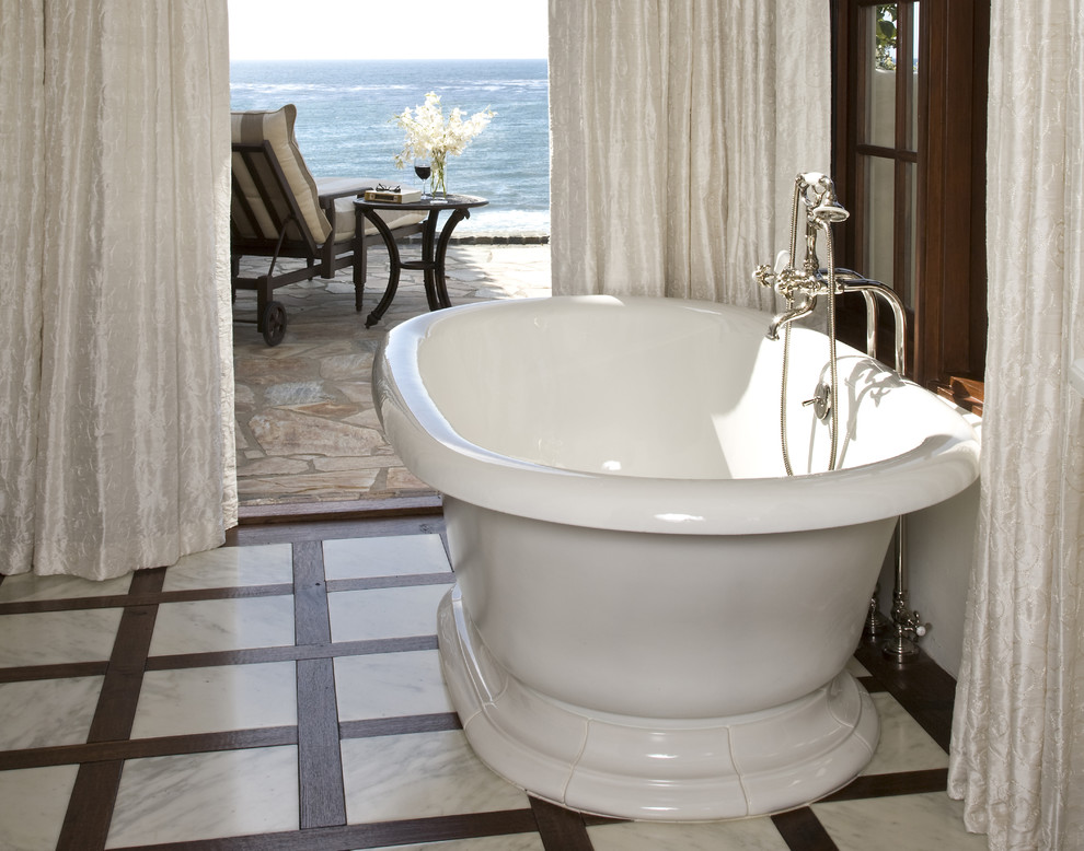 Design ideas for a large mediterranean master bathroom in San Diego with furniture-like cabinets, dark wood cabinets, a freestanding tub, white tile, stone tile, white walls, dark hardwood floors, an undermount sink, marble benchtops, a one-piece toilet and brown floor.