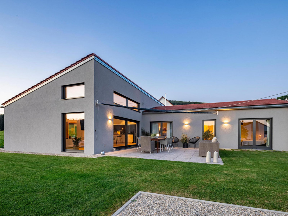 Modernes Bungalow mit grauer Fassadenfarbe, Pultdach und rotem Dach