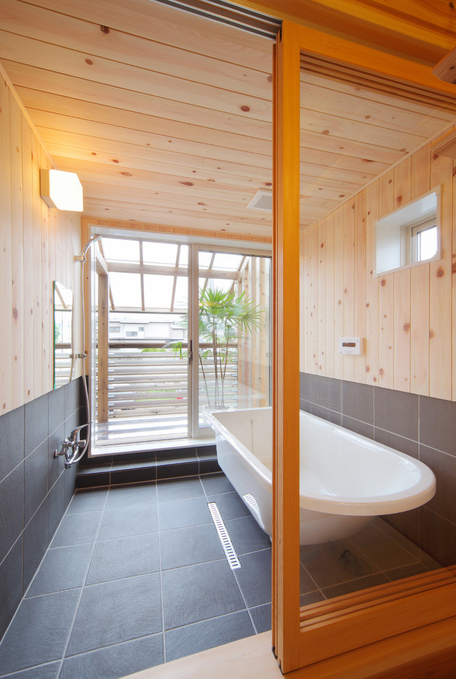 This is an example of an asian bathroom in Other with a freestanding tub, an open shower, brown walls, grey floor and an open shower.