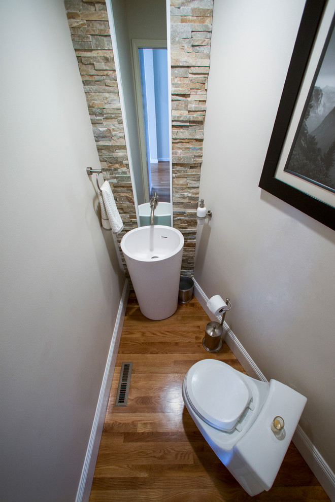 Photo of a small modern powder room in Los Angeles with a bidet, grey walls, light hardwood floors and a pedestal sink.